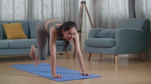 Woman Exercising on Yoga Mat in Living Room