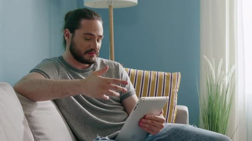 Man Chatting on Tablet Video Call at Home