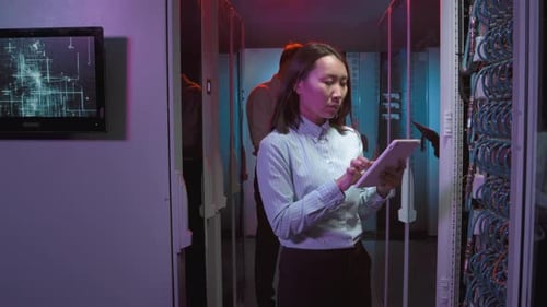 Mulher fazendo anotações no tablet no data center