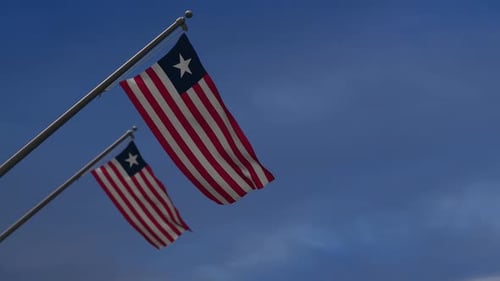 Realistic Liberia Flags Waving in Blue Sky