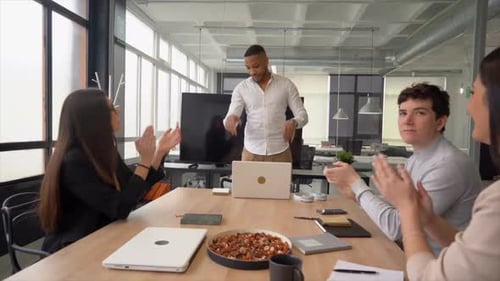 Business Team Applauding Colleague's Presentation in Modern Office
