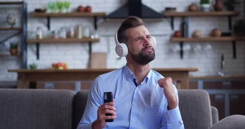 Man Enjoying Music at Home on Couch