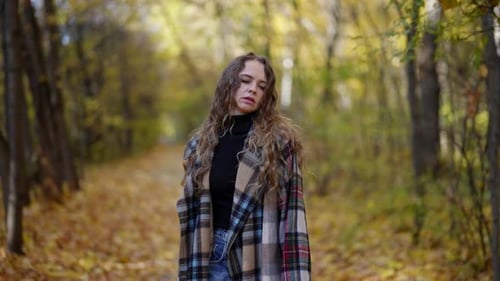 Abandoned Woman is Feeling Sad and Sorrowful Walking Alone in Forest in Fall Day