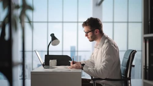 Portrait d'un homme d'affaires réfléchi et prospère travaillant sur un ordinateur portable dans son bureau de la grande ville