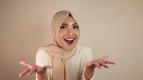 Young Asian Islam woman wearing headscarf is shocked.