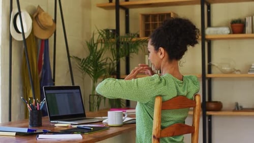 Young Adult Stretching at Desk While Working At Home