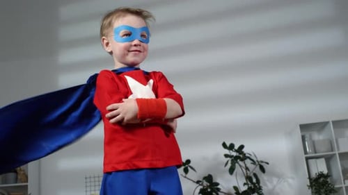 Blond Boy in Superhero Costume Posing Indoors