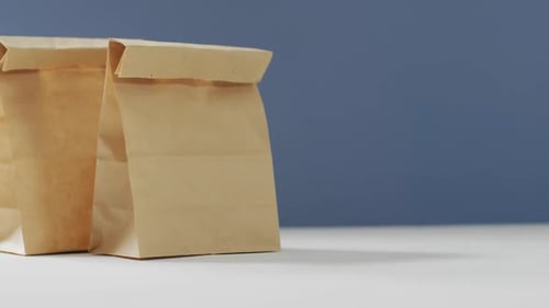 Animación de bolsas de almuerzo de papel sobre fondo azul