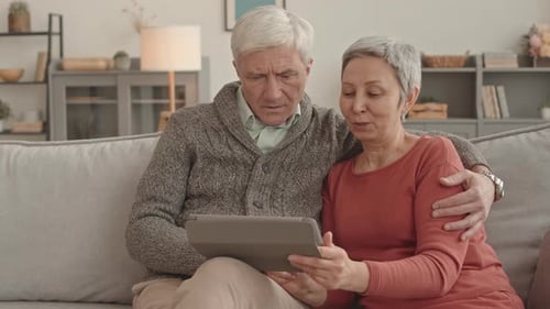 Senior Couple Relaxing at Home Using Tablet