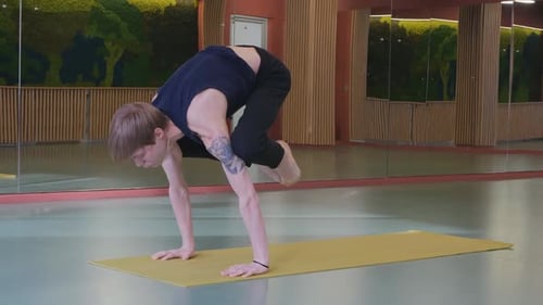 a Young Cute Guy Does a Very Difficult Yoga Asan