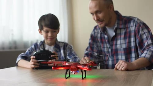 Boy Pilots Drone with Father's Encouragement Indoors