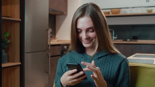 Woman Relaxing at Home Using Her Smartphone
