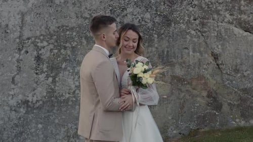 Bride and Groom Embrace in Front of Rocky Cliff