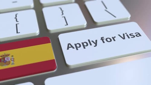Pressing 'Apply for Visa' Key with Spanish Flag on Keyboard
