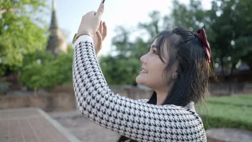 Asian Girl Takes a Picture with a Phone of Wat Yai Chai Mongkhon Temple Thailand Slow Motion Closeup