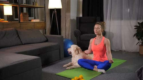 Woman Meditating with Dog in Living Room