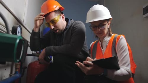 Engineers Inspecting Industrial Equipment Wearing Hardhats
