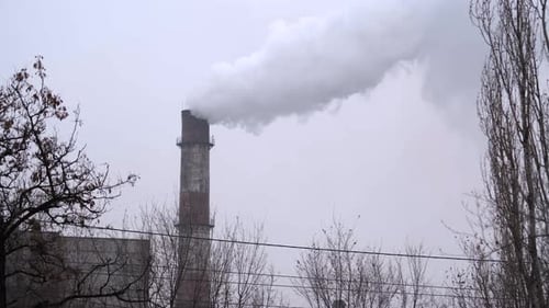 Industrial Chimney Spewing Smoke into Overcast Sky