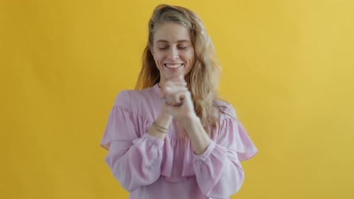 Happy Woman Dancing Against a Yellow Background