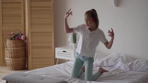 Girl Dances to Music on Bed with Headphones