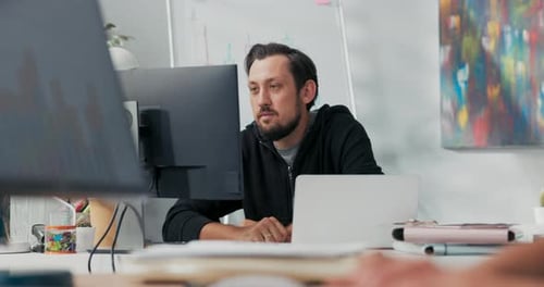 Zufriedener Büroangestellter sitzt vor dem Computerbildschirm und freut sich über eine Werbe-E-Mail