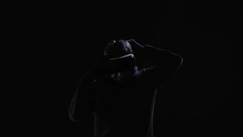Man Puts on VR Headset in Dark Setting