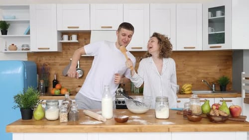 Happy Couple Dancing and Singing in Kitchen