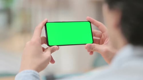 Man Watching Smartphone with Green Chroma Key Screen