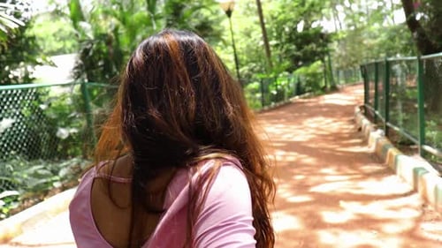 Woman Smiles Walking Through a Tropical Park