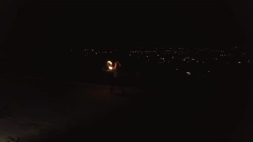 Person Juggling Fire Torches at Night