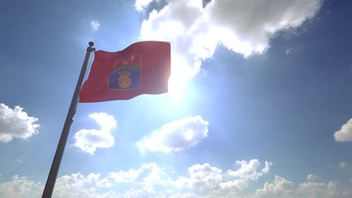 Red Flag with Coat of Arms Waving Against Sunny Sky