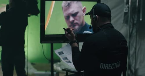 El director da instrucciones y observa la escena en el monitor