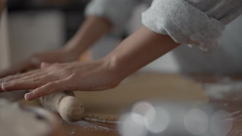 Hands Rolling Dough in Bright Kitchen