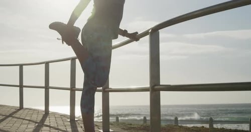 Senior woman stretching her legs on a promenade