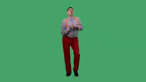 Man dancing in bright red pants against green screen