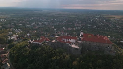 Drone Flies Over Medieval Castle on Mountain in Small European City at Cloudy Autumn Day