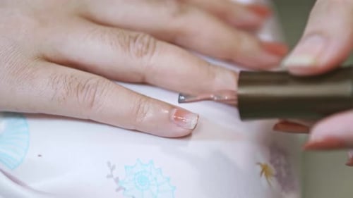Closeup of a woman paints her nails by self made manicure at home slow motion scene. 4K 25fps