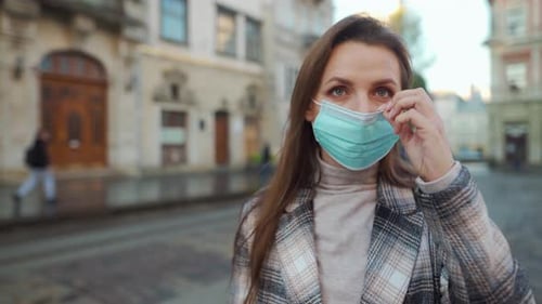 Pandemic Protection of the Covid-19 Coronavirus. Woman in a Coat Stands in the Middle of the Square