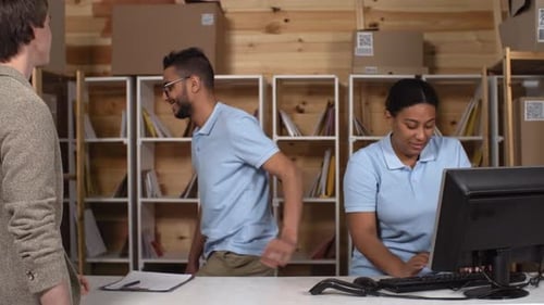Two Multiethnic Post Office Clerks Serving Customer