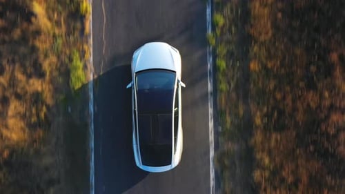 Aerial Shot of Electrical Car Driving on Country Road at Summer Evening