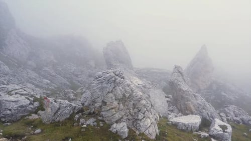 Drone flight over the foggy rocks of the Dolomites