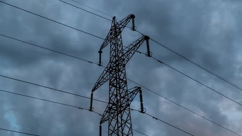 Silhouetted Electrical Tower Against Stormy Dark Clouds