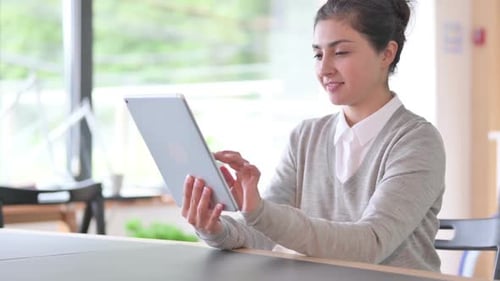 Young Adult Woman Uses Tablet in Office