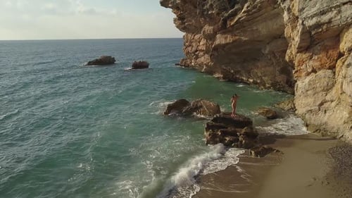 Aerial View of Woman on Rocky Beach