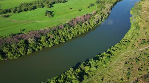 Aerial Footage of a Large River Surrounded By Green Fields