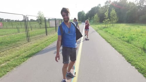 Young cheerful skater having fun riding skate with friends