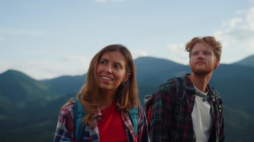 Young Couple Hiking Through Green Mountain Landscape