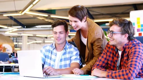 Team Collaborating on Laptop in Modern Office