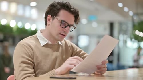 Young Adult Reading Good News on Document