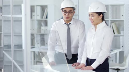 Architects Discussing Plans in Modern Office